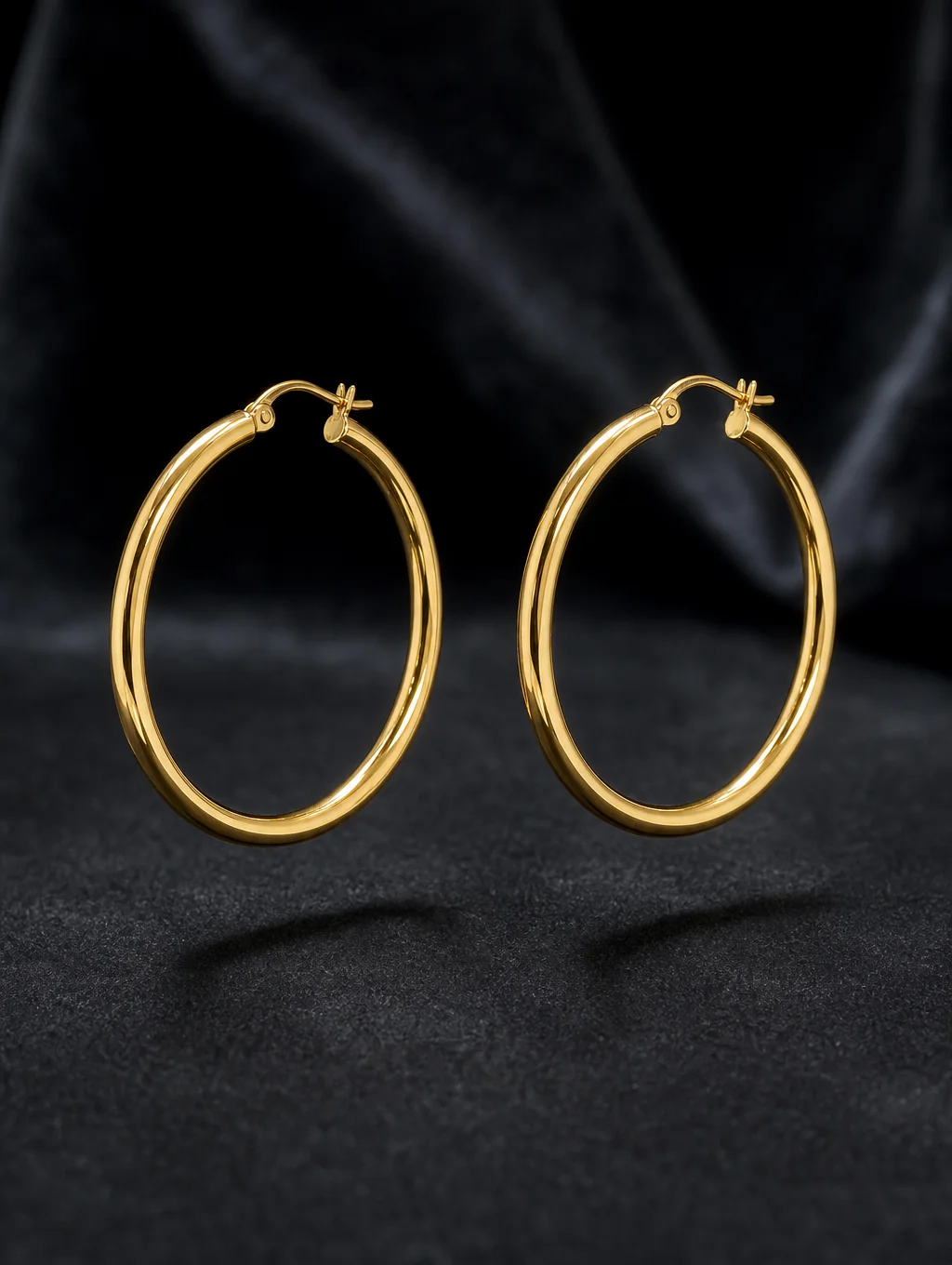 Hand-finished sterling silver earrings on a neutral gallery background